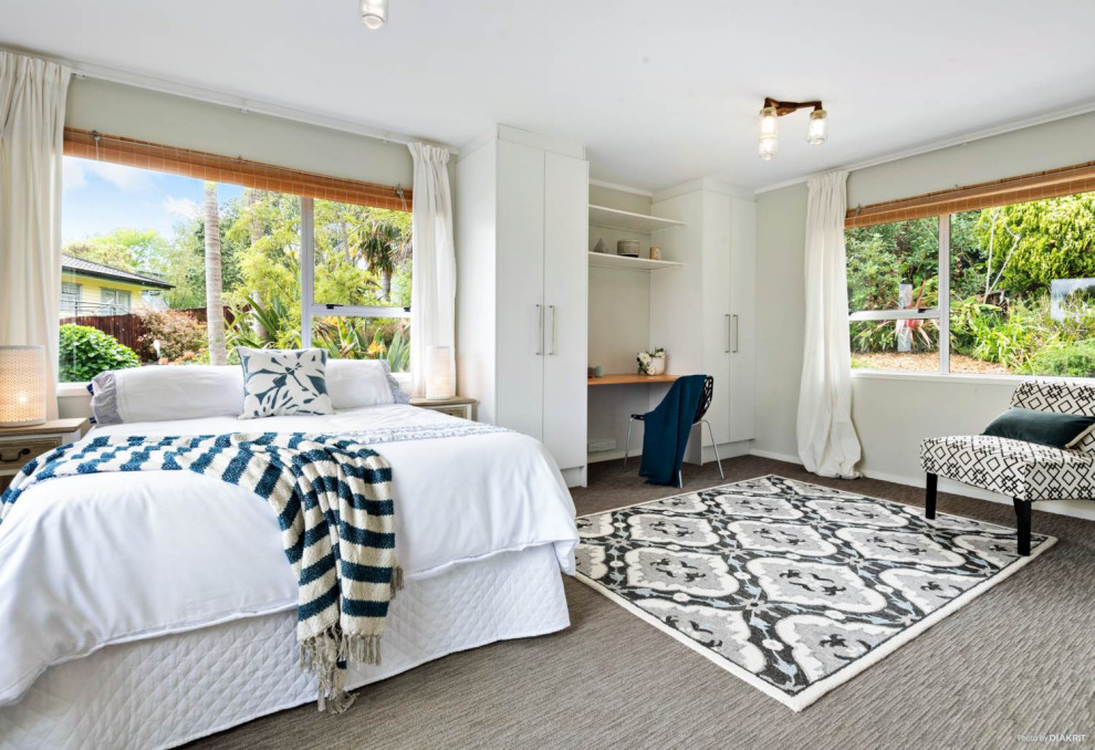 Geräumiges Retro Hauptschlafzimmer mit beiger Wandfarbe, Teppichboden und grauem Boden in Auckland