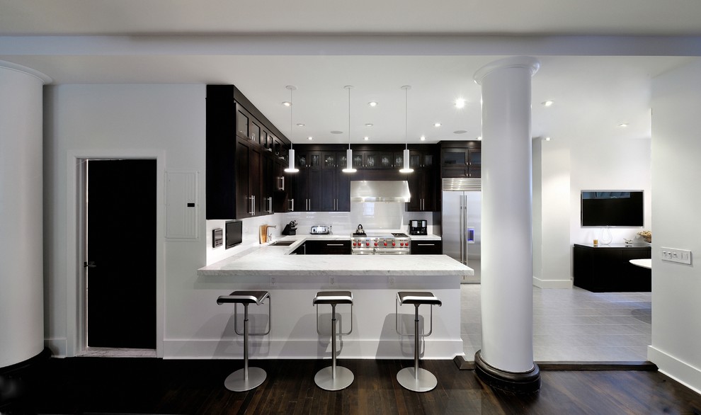 Design ideas for a large contemporary u-shaped eat-in kitchen in New York with an undermount sink, shaker cabinets, dark wood cabinets, marble benchtops, white splashback, stone tile splashback, stainless steel appliances, porcelain floors and a peninsula.