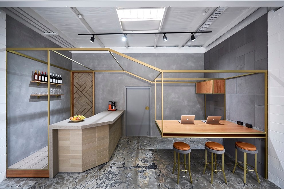 Inspiration for an industrial l-shaped seated home bar in Melbourne with brown cabinets, concrete benchtops, grey splashback and concrete floors.