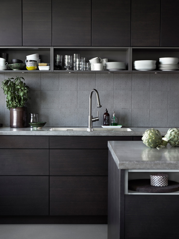 Inspiration for a mid-sized contemporary kitchen in Malmo with a drop-in sink, flat-panel cabinets, dark wood cabinets, black splashback, stainless steel appliances, with island and granite benchtops.