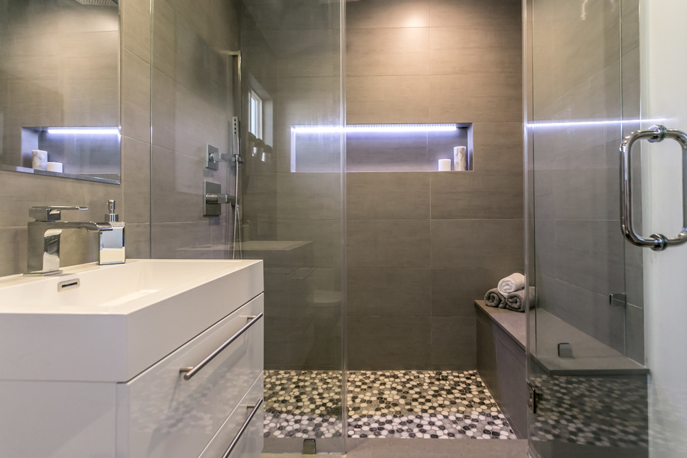 Inspiration for a mid-sized contemporary bathroom in Los Angeles with white cabinets, a wall-mount toilet, gray tile, porcelain tile, grey walls, porcelain floors, an integrated sink and with a sauna.