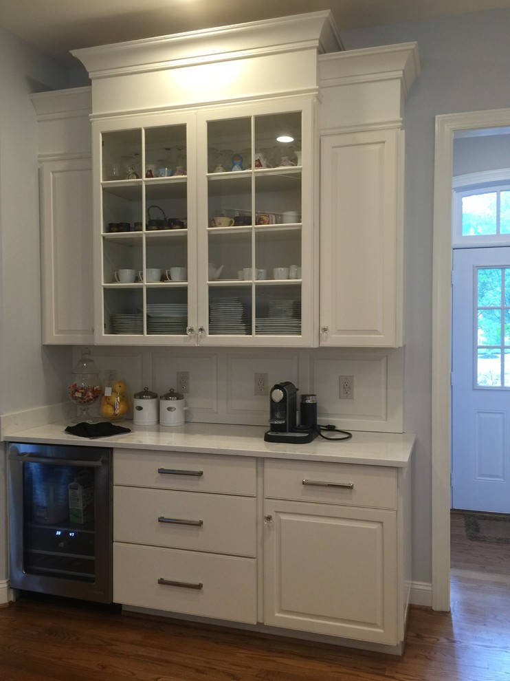 Inspiration for a large transitional u-shaped medium tone wood floor open concept kitchen remodel in DC Metro with an undermount sink, raised-panel cabinets, white cabinets, quartzite countertops, stainless steel appliances and an island