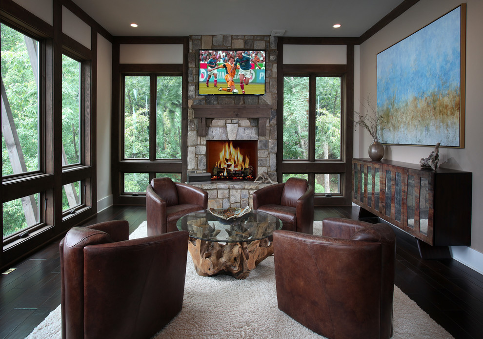 Photo of a country family room in Atlanta with dark hardwood floors, a standard fireplace and a stone fireplace surround.