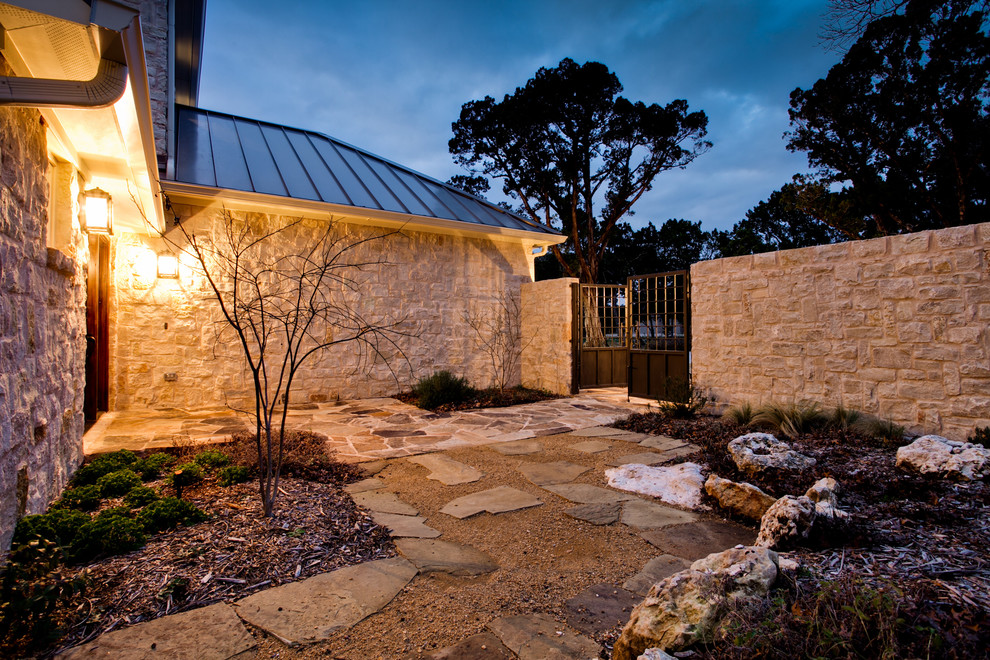 Design ideas for a large traditional side yard full sun xeriscape for winter in Dallas with natural stone pavers and a retaining wall.