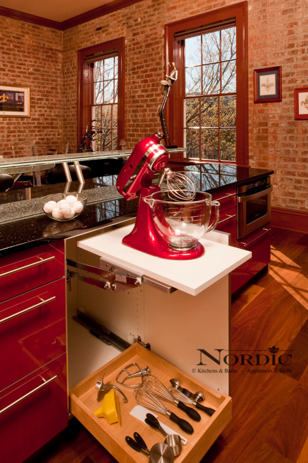 Photo of a mid-sized contemporary single-wall eat-in kitchen in New Orleans with an undermount sink, flat-panel cabinets, red cabinets, granite benchtops, panelled appliances, beige splashback, glass tile splashback, dark hardwood floors and with island.