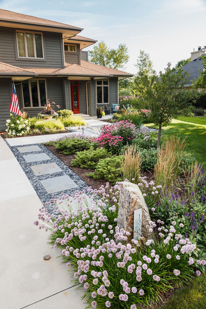This is an example of a mid-sized asian front yard full sun xeriscape for summer in Milwaukee with a garden path and natural stone pavers.