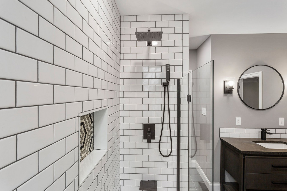 This is an example of a large modern master bathroom in Philadelphia with white tile, subway tile, porcelain floors, engineered quartz benchtops, grey floor, a hinged shower door, black benchtops, a laundry and a single vanity.