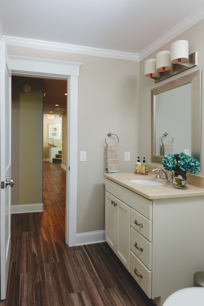 Photo of a beach style bathroom in Atlanta with beige walls, porcelain floors, an undermount sink, recessed-panel cabinets, white cabinets, brown tile, porcelain tile and quartzite benchtops.
