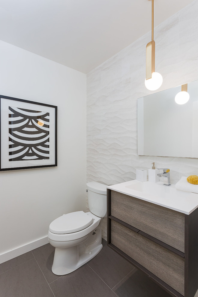 Mid-sized trendy porcelain tile and brown floor powder room photo in San Francisco with flat-panel cabinets, medium tone wood cabinets, a one-piece toilet, white walls, an integrated sink, quartz countertops and white countertops