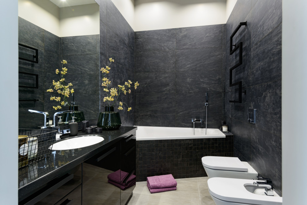 Photo of a large contemporary master bathroom in Novosibirsk with flat-panel cabinets, black cabinets, an alcove tub, a wall-mount toilet, black tile, ceramic tile, black walls, ceramic floors, an undermount sink, solid surface benchtops, grey floor and black benchtops.
