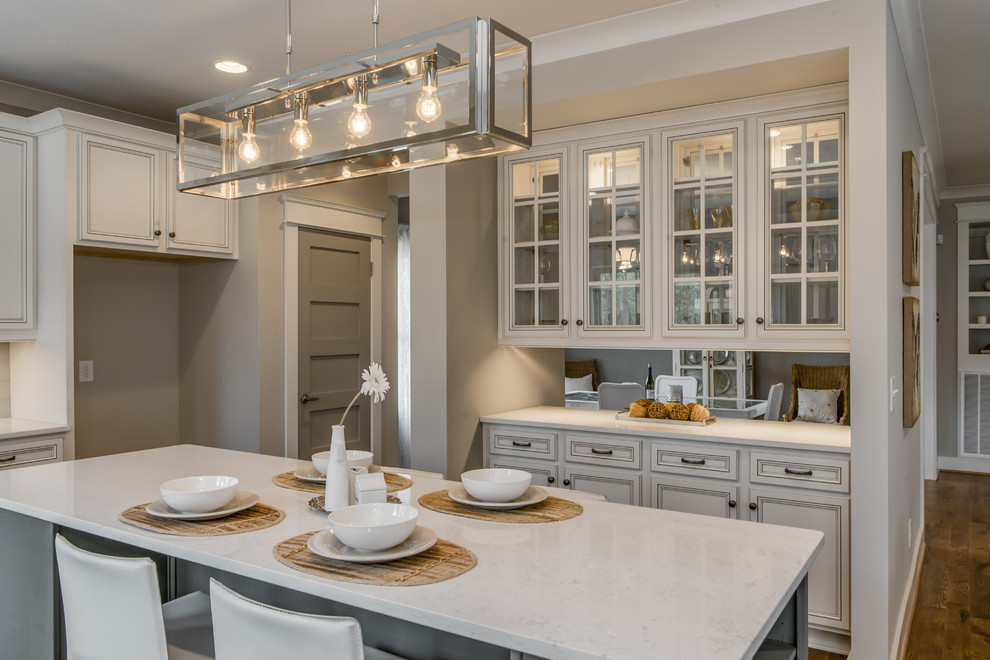 Inspiration for a mid-sized transitional l-shaped open plan kitchen in Nashville with an undermount sink, flat-panel cabinets, white cabinets, quartz benchtops, grey splashback, subway tile splashback, stainless steel appliances, medium hardwood floors and with island.
