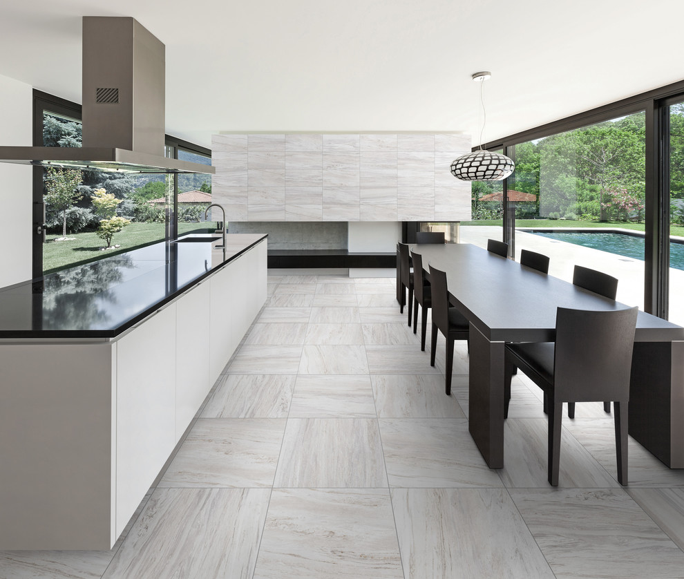 Design ideas for a mid-sized modern single-wall eat-in kitchen in Toronto with porcelain floors, a drop-in sink, flat-panel cabinets, white cabinets, granite benchtops, stainless steel appliances and with island.