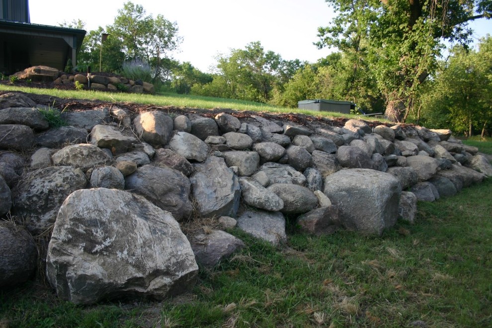 Inspiration for a large traditional backyard garden in Omaha with a retaining wall.