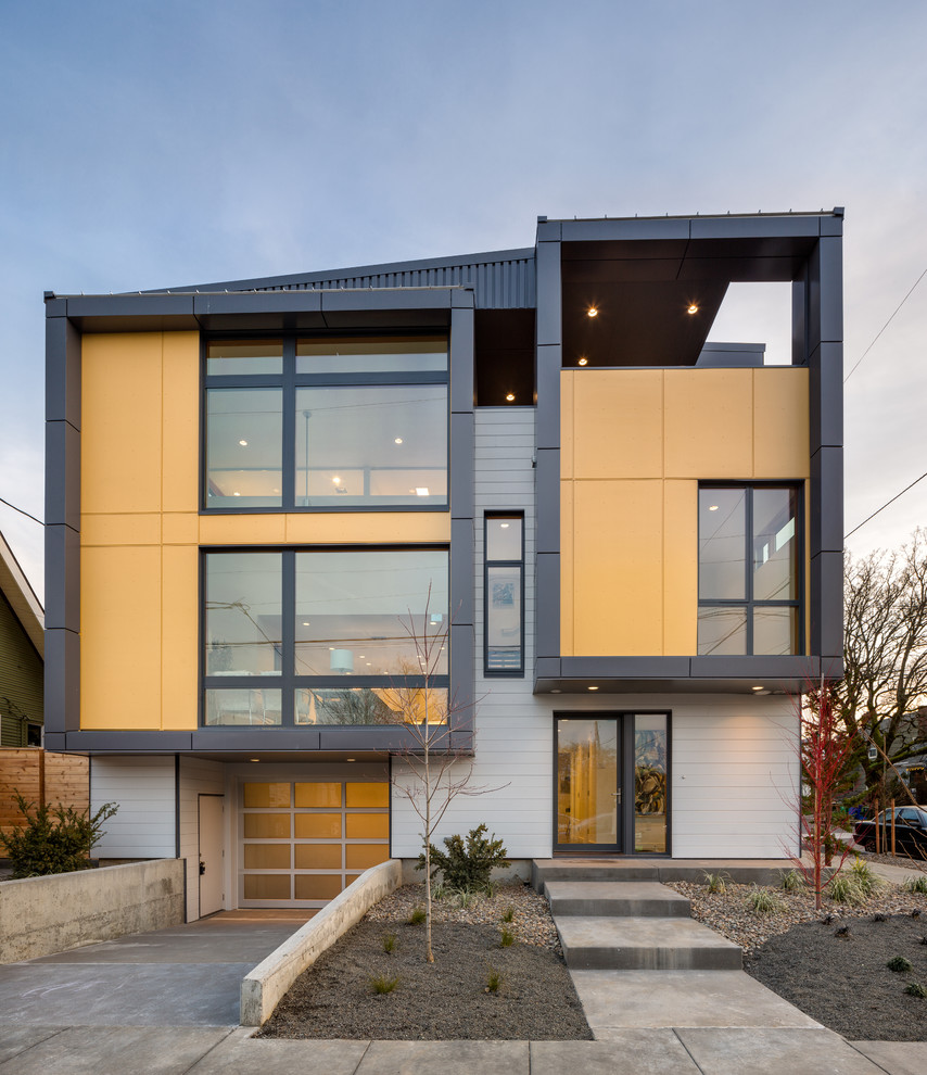 This is an example of a mid-sized contemporary split-level grey townhouse exterior in Portland with metal siding, a shed roof and a metal roof.