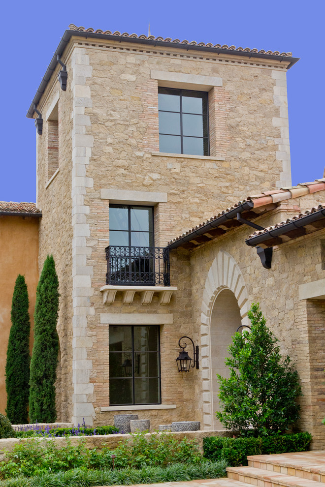 Photo of a large mediterranean three-storey brown exterior in Orange County with mixed siding and a gable roof.