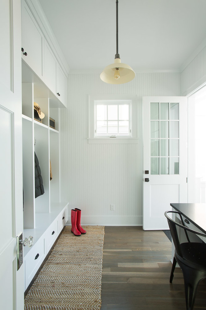 Mid-sized transitional mudroom in Seattle with white walls, dark hardwood floors and a glass front door.