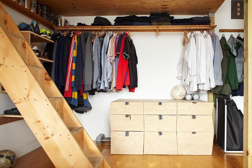 Scandinavian men's walk-in wardrobe in New York with open cabinets, light wood cabinets and medium hardwood floors.