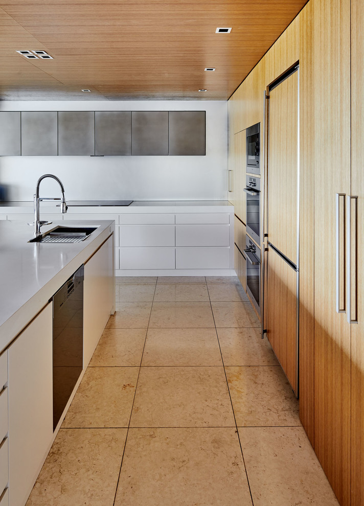Inspiration for a large contemporary l-shaped open plan kitchen in Sydney with an undermount sink, flat-panel cabinets, medium wood cabinets, stainless steel appliances, with island, beige floor, quartz benchtops, beige splashback, glass sheet splashback and limestone floors.