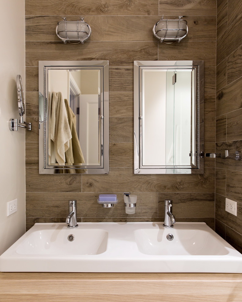 Midcentury bathroom in New York with light wood cabinets, brown walls and an integrated sink.
