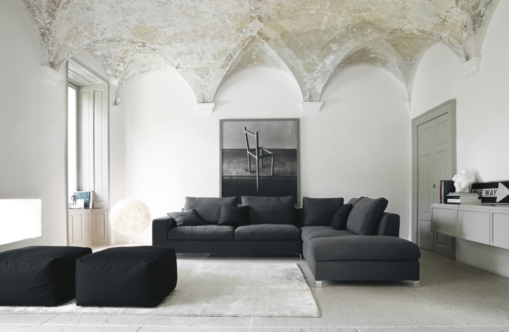This is an example of a large contemporary open concept family room in Milan with white walls, no fireplace, no tv and white floor.