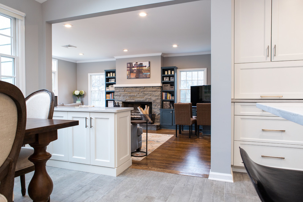 Large transitional ceramic tile open concept kitchen photo in New York with an undermount sink, shaker cabinets, white cabinets, quartz countertops, gray backsplash, ceramic backsplash, stainless steel appliances and an island