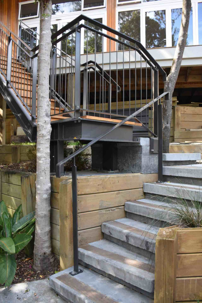 Design ideas for a medium sized urban wood l-shaped metal railing staircase in Auckland with wood risers.