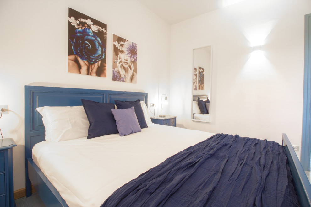Идея дизайна: хозяйская спальня среднего размера в современном стиле с белыми стенами, полом из ламината, бирюзовым полом, многоуровневым потолком и панелями на стенах без камина