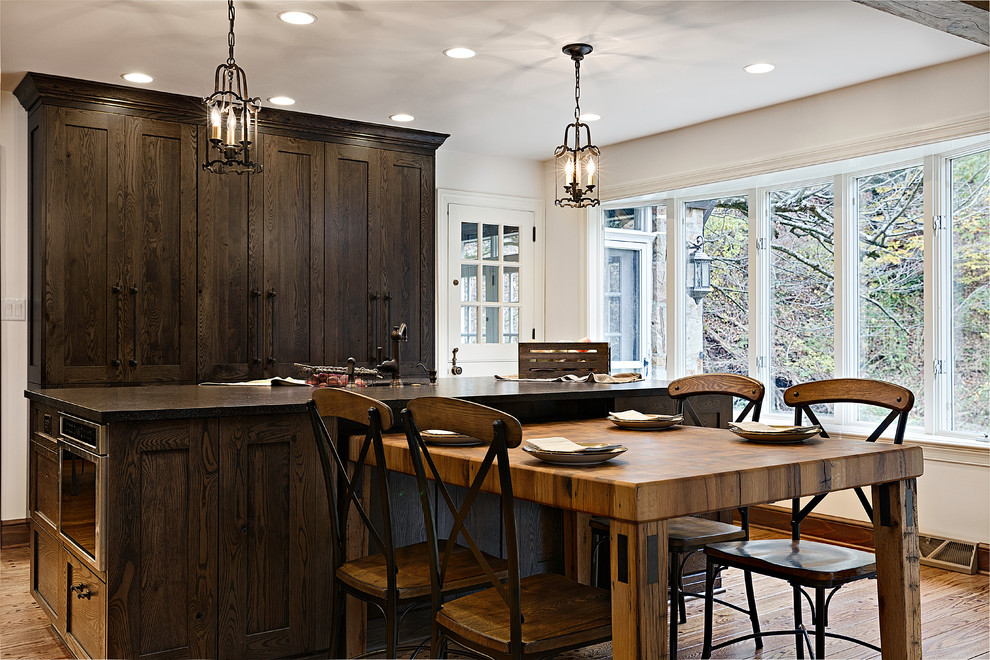 Inspiration for a mid-sized transitional eat-in kitchen in DC Metro with a single-bowl sink, medium hardwood floors, recessed-panel cabinets, dark wood cabinets, granite benchtops, multi-coloured splashback, ceramic splashback, stainless steel appliances and with island.