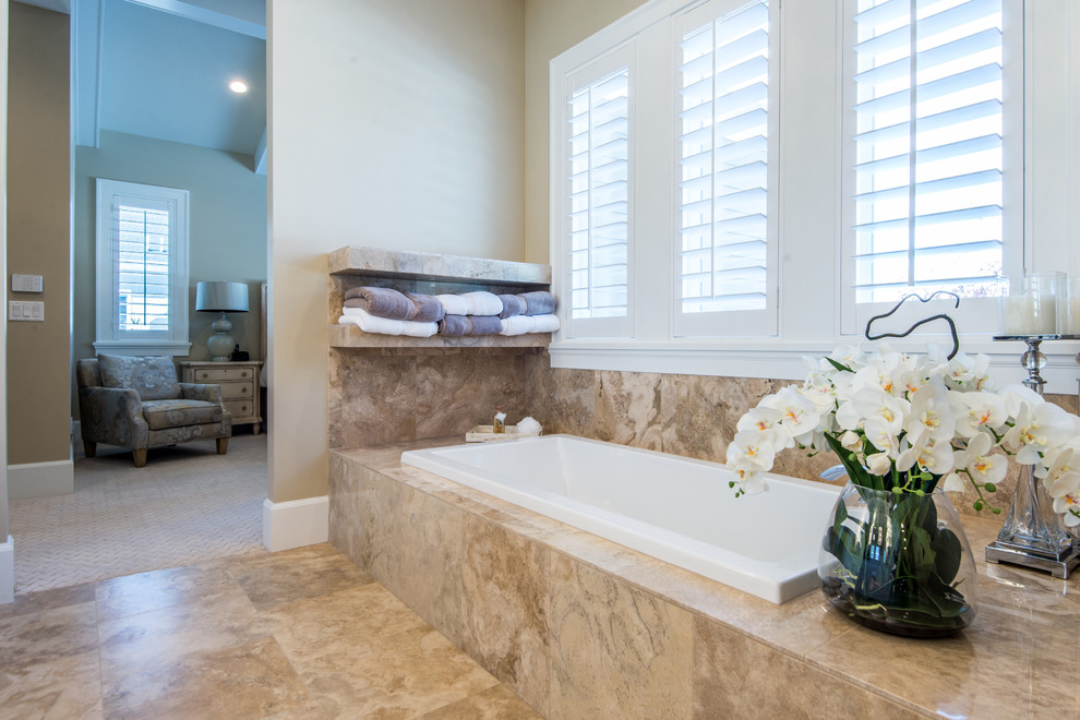 This is an example of a mid-sized traditional master bathroom in Salt Lake City with a drop-in tub, beige tile, beige walls, travertine floors, granite benchtops, raised-panel cabinets, white cabinets, a curbless shower, a one-piece toilet, an undermount sink and travertine.
