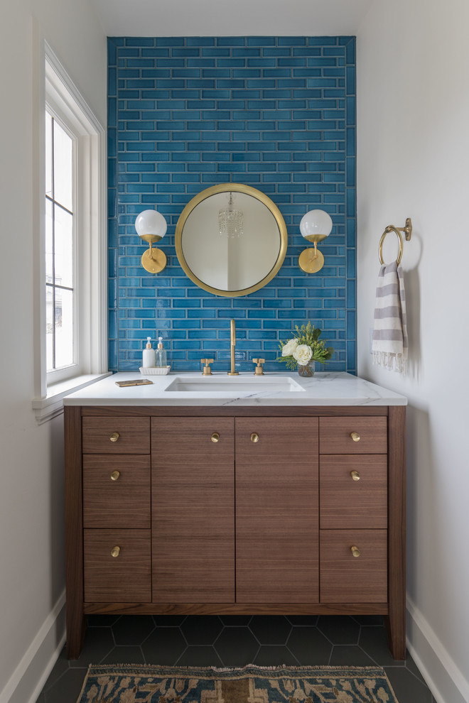 Example of a transitional blue tile black floor powder room design with flat-panel cabinets, white walls, an undermount sink and white countertops