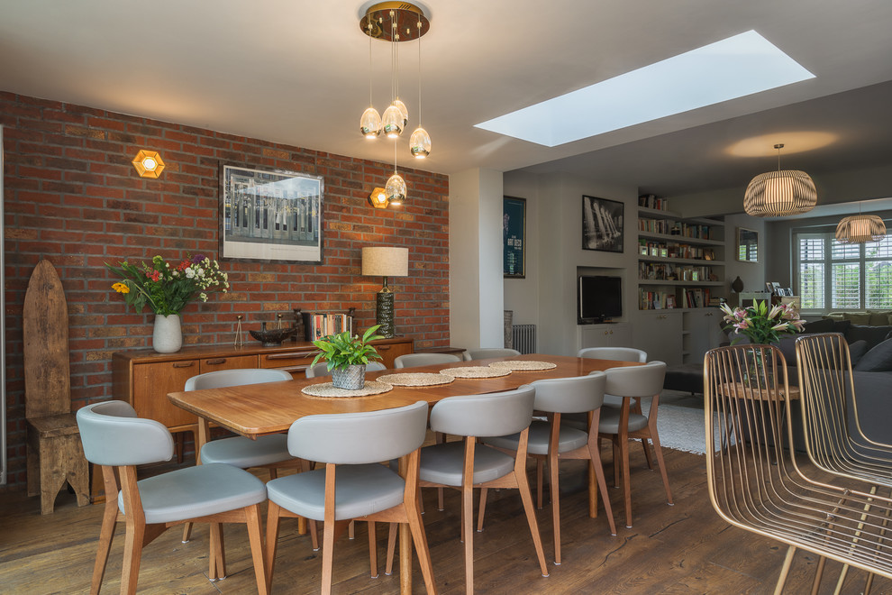 Photo of a mid-sized contemporary open plan dining in London with brown floor, white walls and dark hardwood floors.