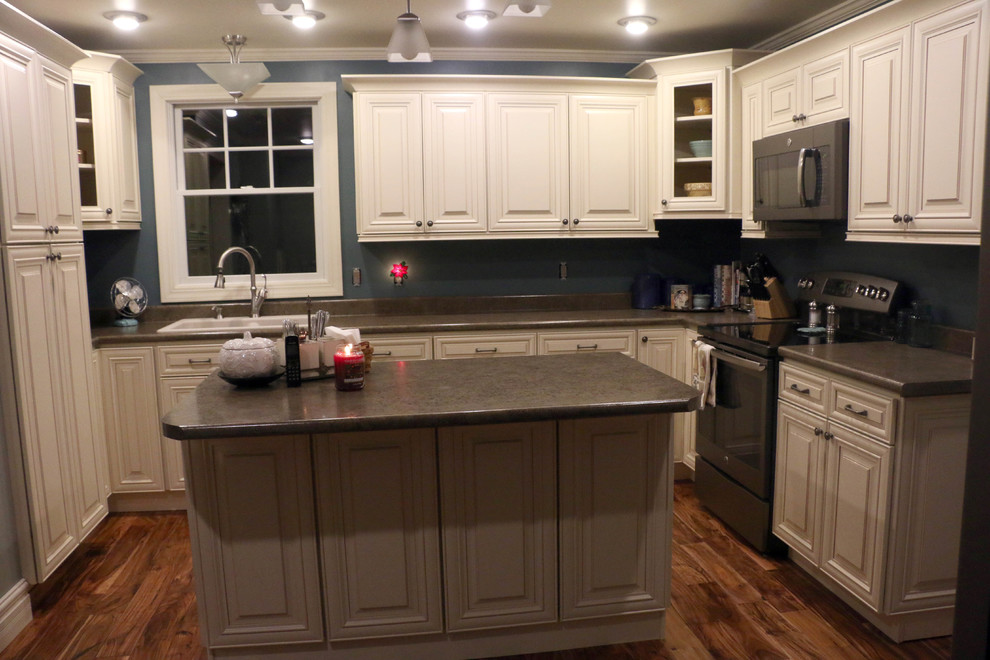 Enclosed kitchen - mid-sized traditional u-shaped dark wood floor enclosed kitchen idea with a drop-in sink, raised-panel cabinets, white cabinets, granite countertops, blue backsplash, stainless steel appliances and an island