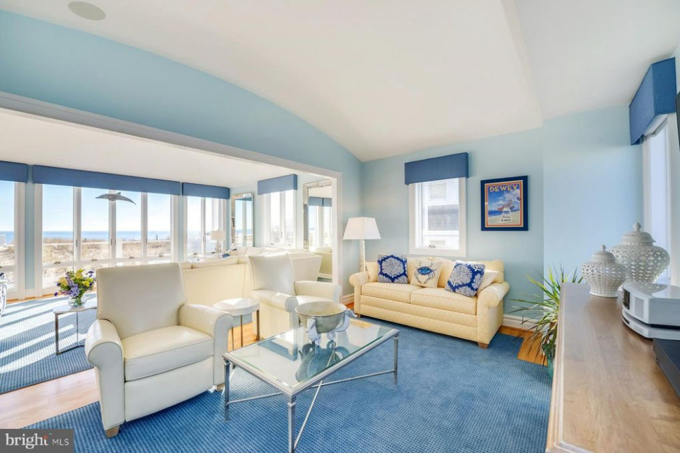 Inspiration for a large beach style open concept living room in Other with blue walls, light hardwood floors and a wall-mounted tv.