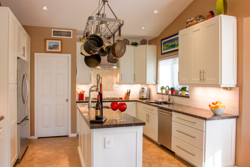 Eat-in kitchen - mid-sized transitional u-shaped porcelain tile and brown floor eat-in kitchen idea in Phoenix with an undermount sink, shaker cabinets, white cabinets, white backsplash, subway tile backsplash, stainless steel appliances, an island, granite countertops and brown countertops