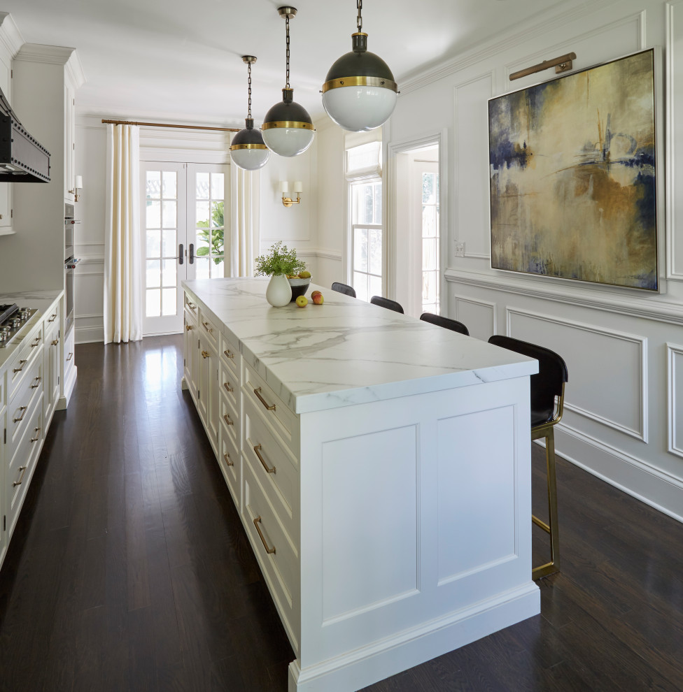 Design ideas for a mid-sized transitional l-shaped separate kitchen in Chicago with a farmhouse sink, recessed-panel cabinets, white cabinets, quartz benchtops, white splashback, stone slab splashback, panelled appliances, dark hardwood floors, with island, black floor and white benchtop.