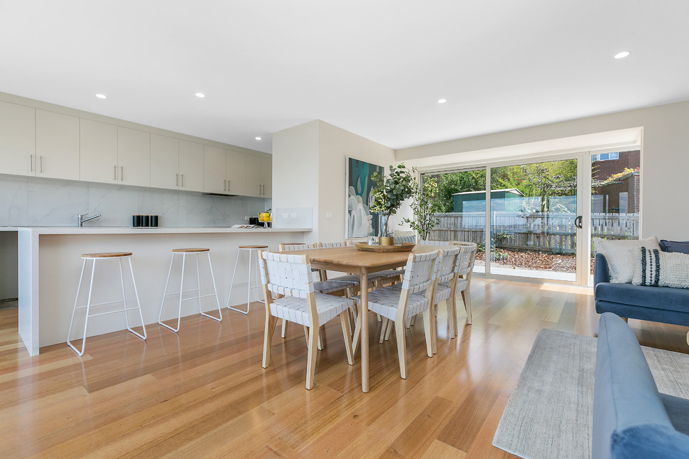 Photo of a beach style open plan dining in Hobart with grey walls, medium hardwood floors and beige floor.