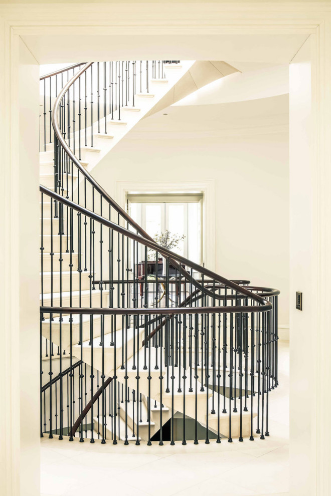Пример оригинального дизайна: винтовая лестница с ступенями из известняка, подступенками из известняка и металлическими перилами
