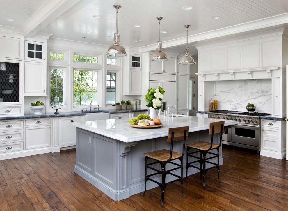 Inspiration for a traditional l-shaped kitchen in San Francisco with a farmhouse sink, recessed-panel cabinets, white cabinets, white splashback, stainless steel appliances, dark hardwood floors and with island.