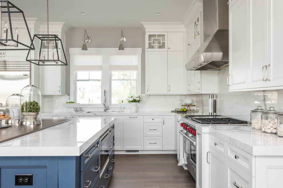 This is an example of a transitional l-shaped kitchen in Indianapolis with an undermount sink, recessed-panel cabinets, white cabinets, white splashback, stainless steel appliances, medium hardwood floors and with island.