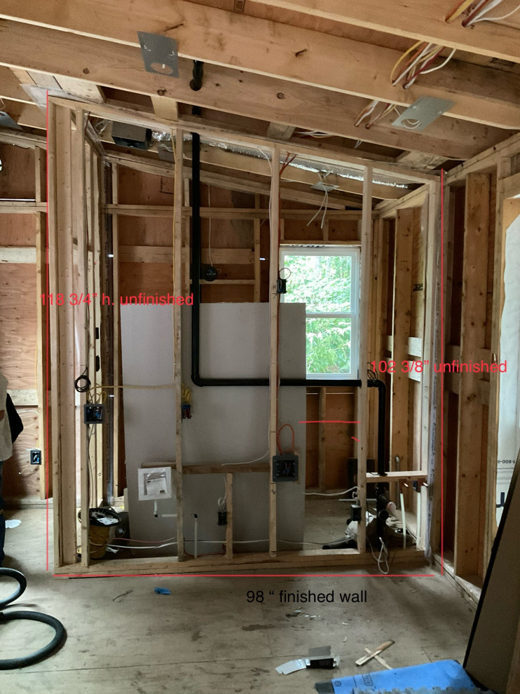 Construction phase of sauna house showing utility rough-in and framing measureme