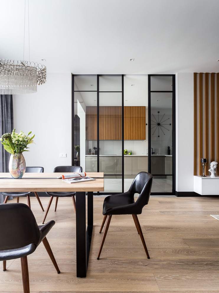 Photo of a contemporary dining room in Moscow with white walls, medium hardwood floors and brown floor.