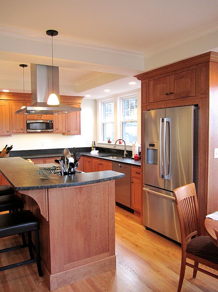 Inspiration for a mid-sized transitional l-shaped eat-in kitchen remodel with an undermount sink, recessed-panel cabinets, medium tone wood cabinets, granite countertops, blue backsplash, stone slab backsplash and stainless steel appliances
