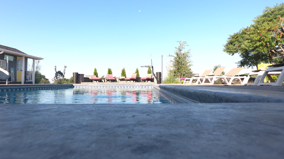 Example of a mid-sized transitional backyard brick and rectangular lap pool house design