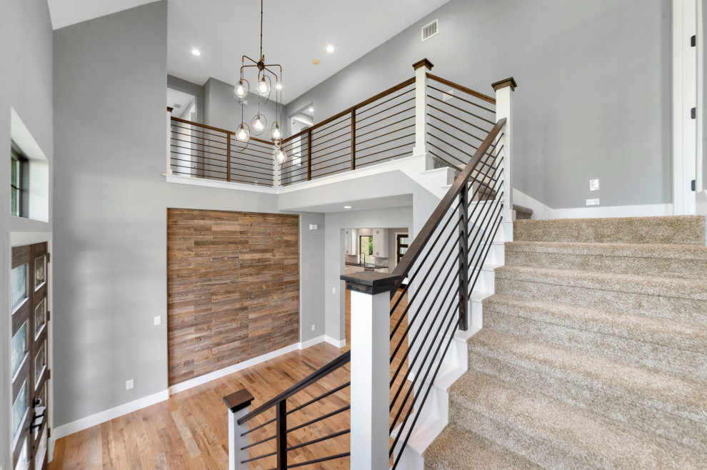 Inspiration for a mid-sized contemporary foyer in Dallas with grey walls, medium hardwood floors, a double front door, a dark wood front door, brown floor and wood walls.