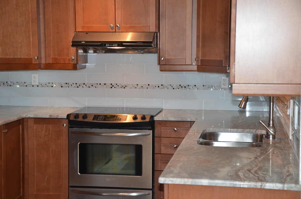 Example of a small transitional u-shaped porcelain tile enclosed kitchen design in Toronto with a double-bowl sink, beaded inset cabinets, medium tone wood cabinets, granite countertops, white backsplash, glass tile backsplash, stainless steel appliances and no island