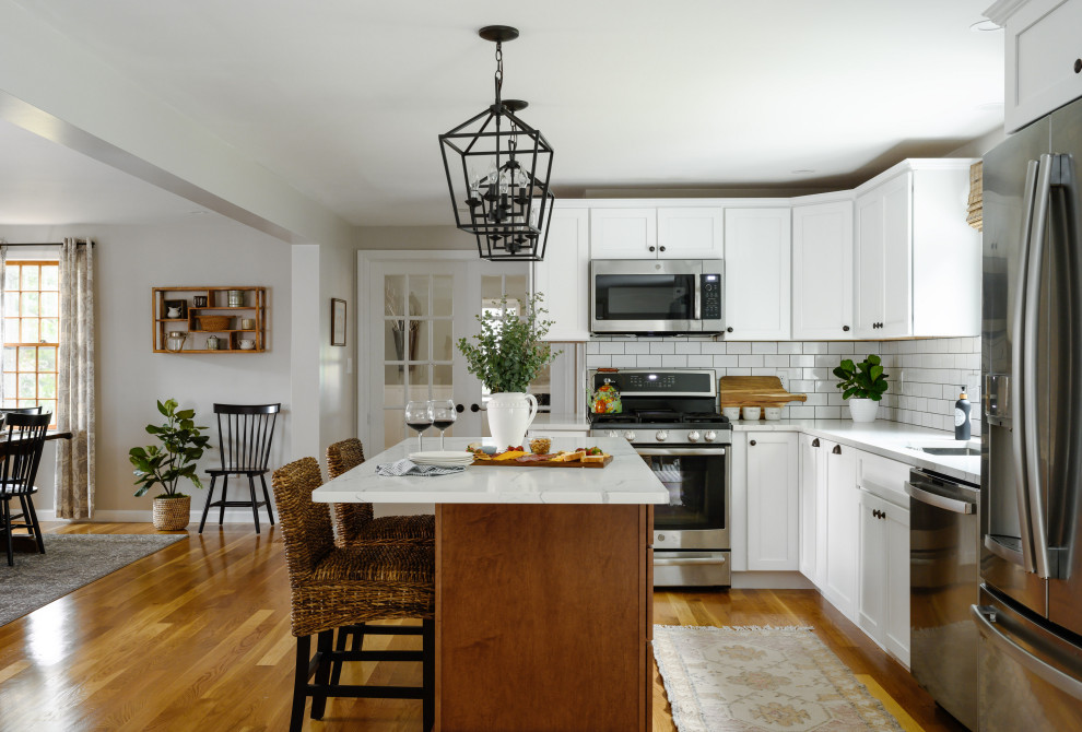 Large elegant l-shaped medium tone wood floor and brown floor eat-in kitchen photo in Boston with an undermount sink, quartzite countertops, white backsplash, subway tile backsplash, stainless steel appliances, an island and white countertops