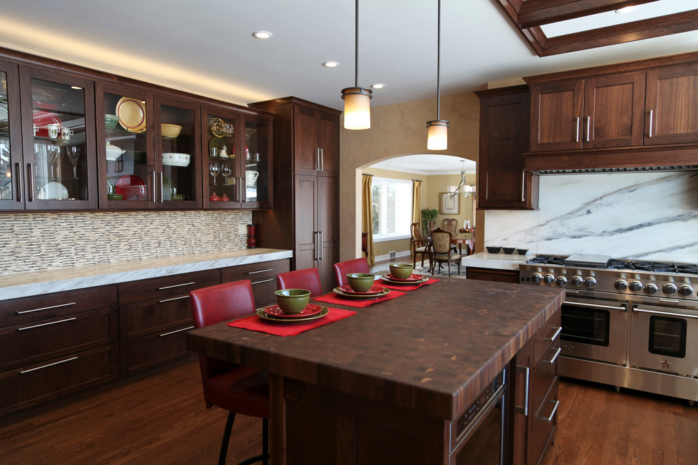 Transitional medium tone wood floor kitchen photo in Chicago with an undermount sink, shaker cabinets, dark wood cabinets, wood countertops, multicolored backsplash, ceramic backsplash and stainless steel appliances
