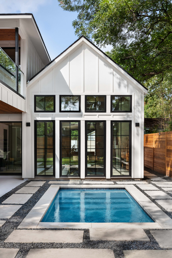 Diseño de piscina campestre pequeña rectangular en patio trasero con adoquines de hormigón