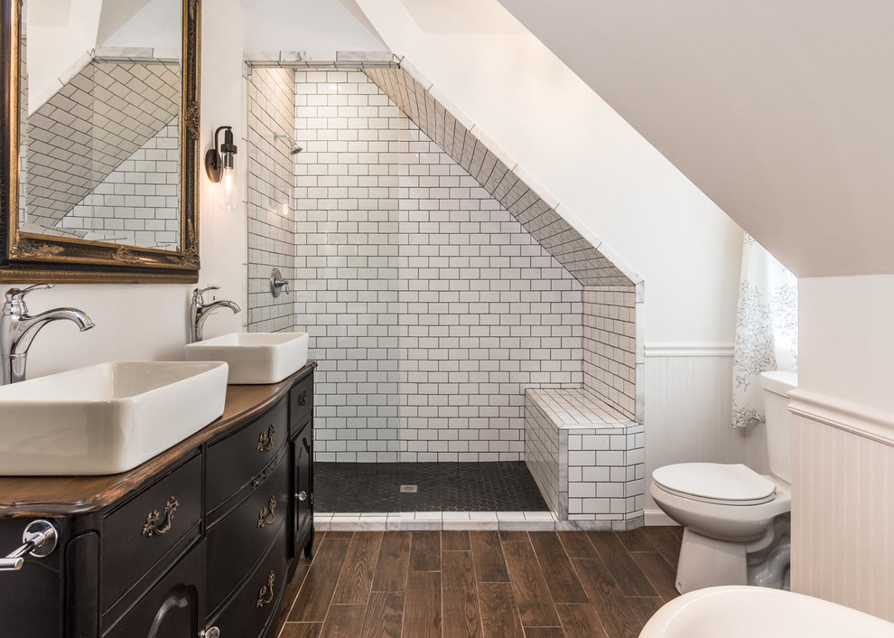 This is an example of a mid-sized eclectic master bathroom in Nashville with a vessel sink, black cabinets, wood benchtops, an alcove shower, a two-piece toilet, black and white tile, porcelain tile, white walls, porcelain floors, brown floor and brown benchtops.