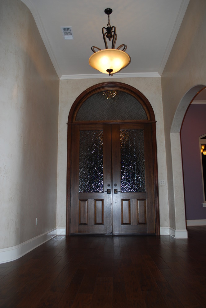 Example of a transitional medium tone wood floor and brown floor front door design with a dark wood front door